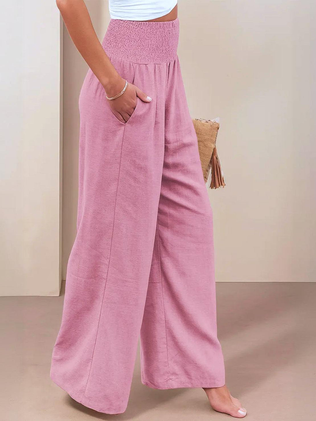 Women’s flowing wide leg pants styled for daily wear on a plain background.