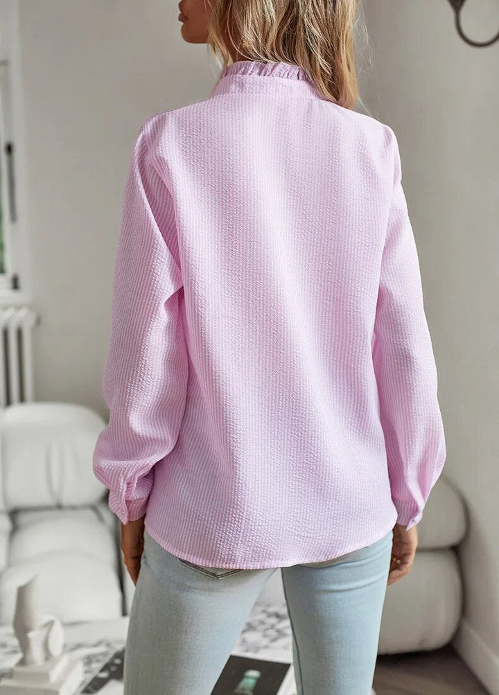 Refined neckline top with soft front drape on a model against a plain background.
