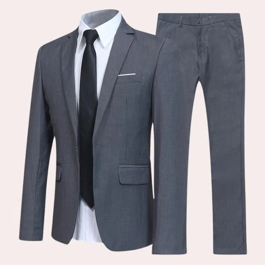 A notch lapel suit with matching trousers on a plain background.