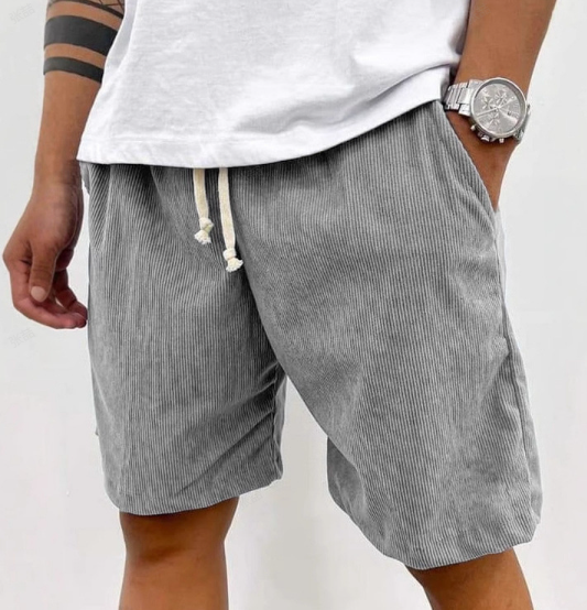 Male model styling lightweight-looking shorts on a plain background.