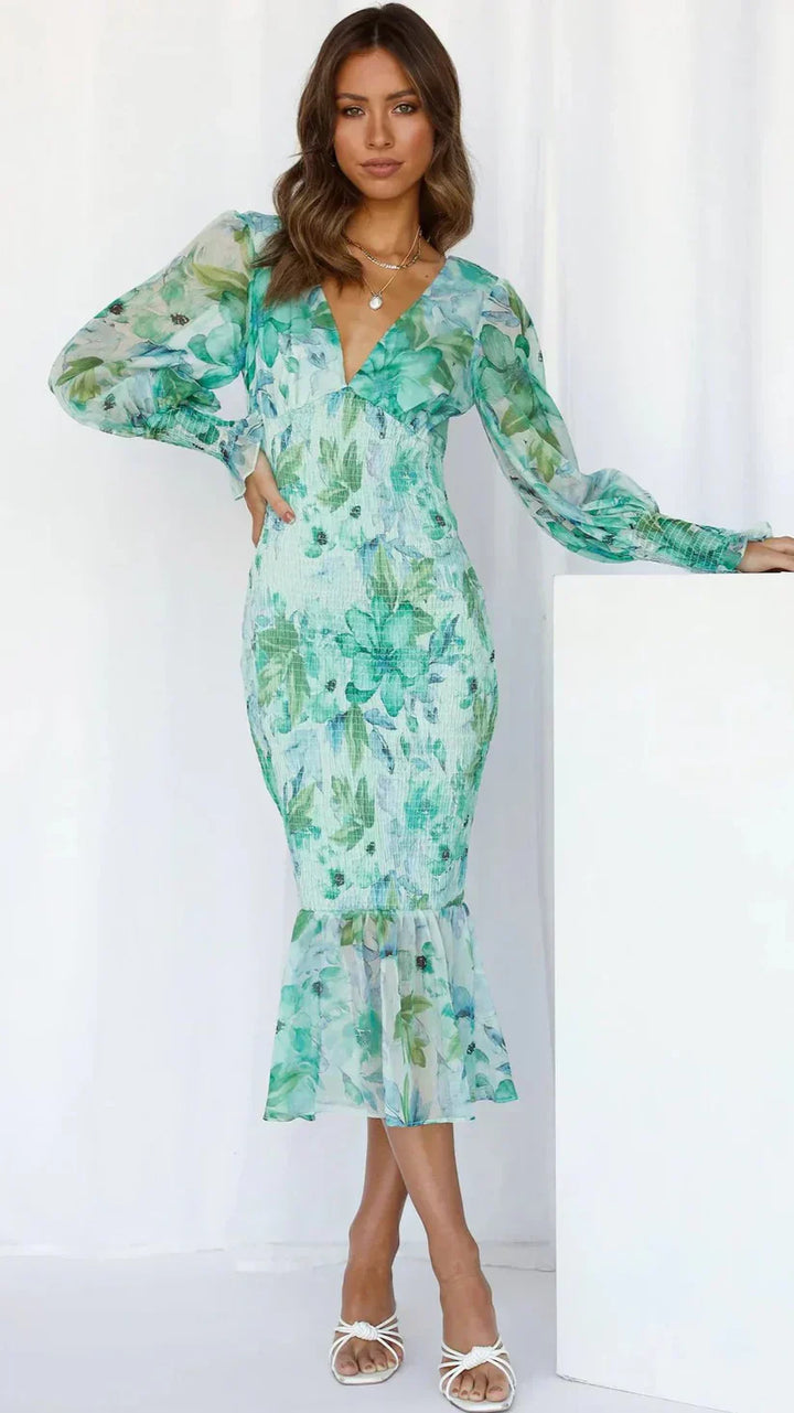 Model wearing a feminine floral dress on a clean background.