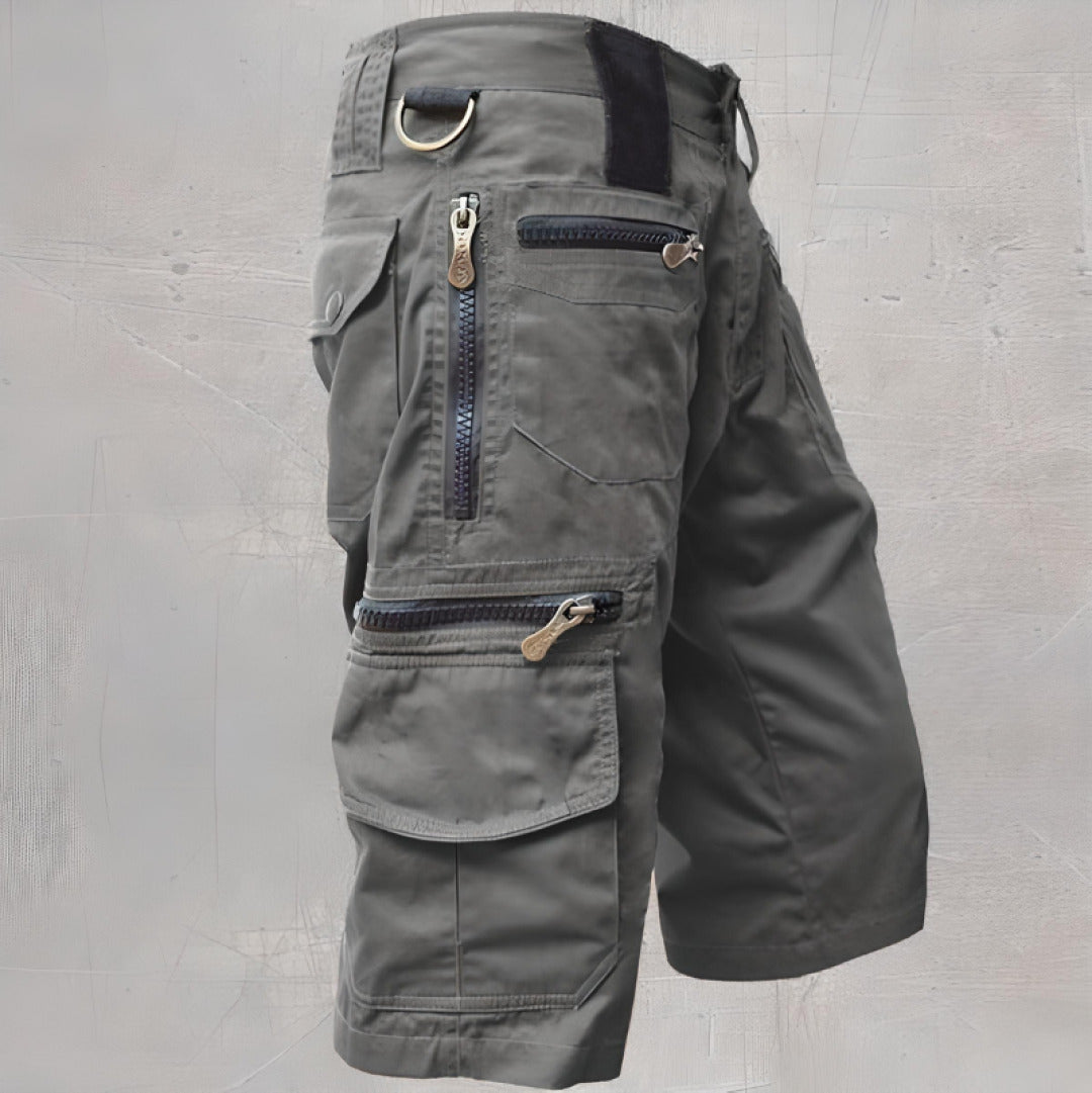 Female model standing in cargo shorts featuring secure zip pockets against a plain background.