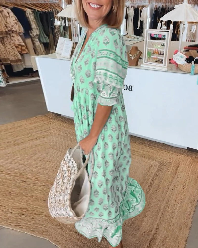 Relaxed midi dress shown on a plain background with soft drape and decorative tassels.