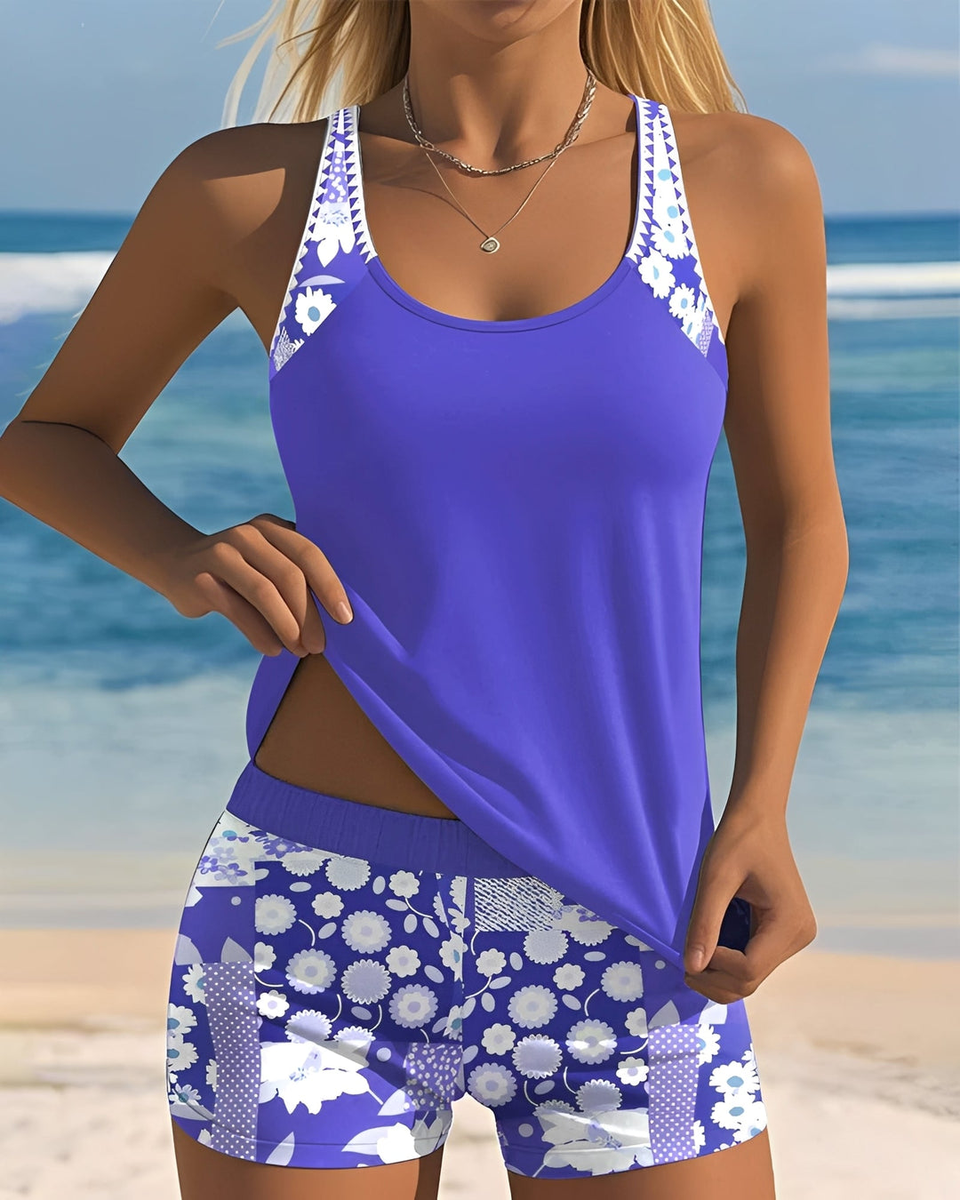  Female model in a stylish patterned swimwear outfit on a plain background.
