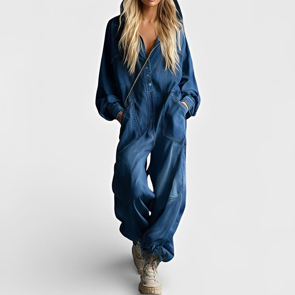 Female model wearing a sleeveless jumpsuit with practical pockets on a plain background.