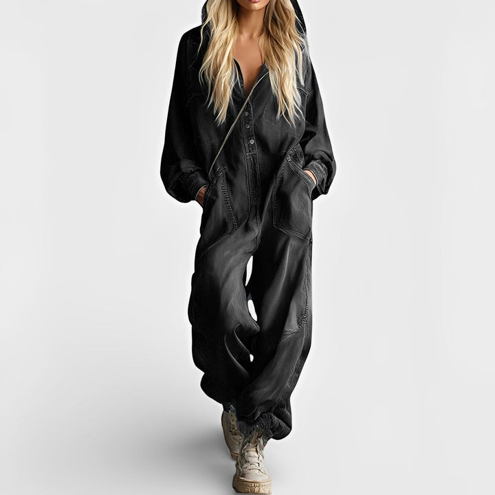  Woman dressed in a casual one-piece outfit standing against a plain background.