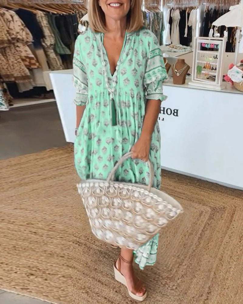 Flowy midi dress on a plain background featuring relaxed drape and boho-inspired details.