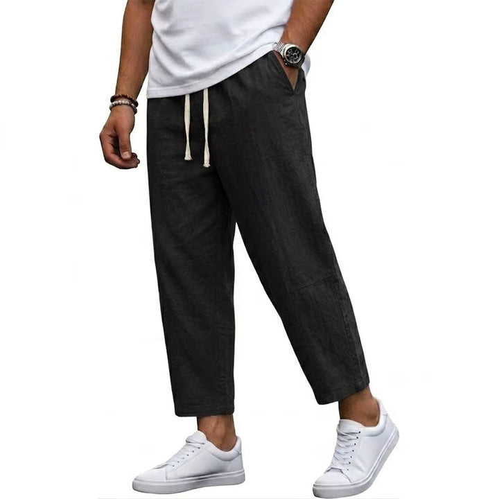 Male model wearing cropped drawstring pants on a plain background.