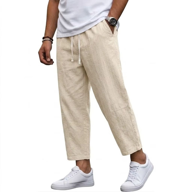  Male model in airy cropped pants with an adjustable waist on a plain background.