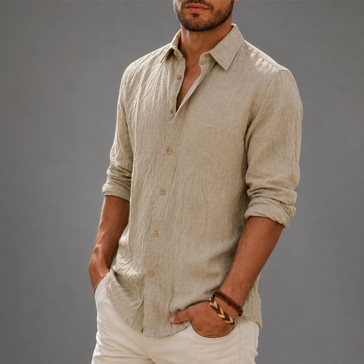 Male model wearing a relaxed button down shirt on a plain background.