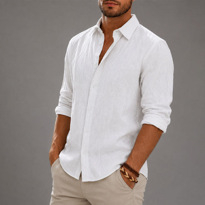  Man in a long sleeve button down shirt shown against a plain background.