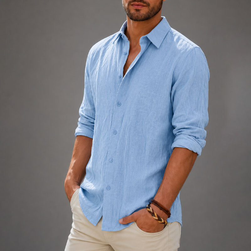  Man wearing an airy long sleeve shirt with a clean casual look on a plain background.