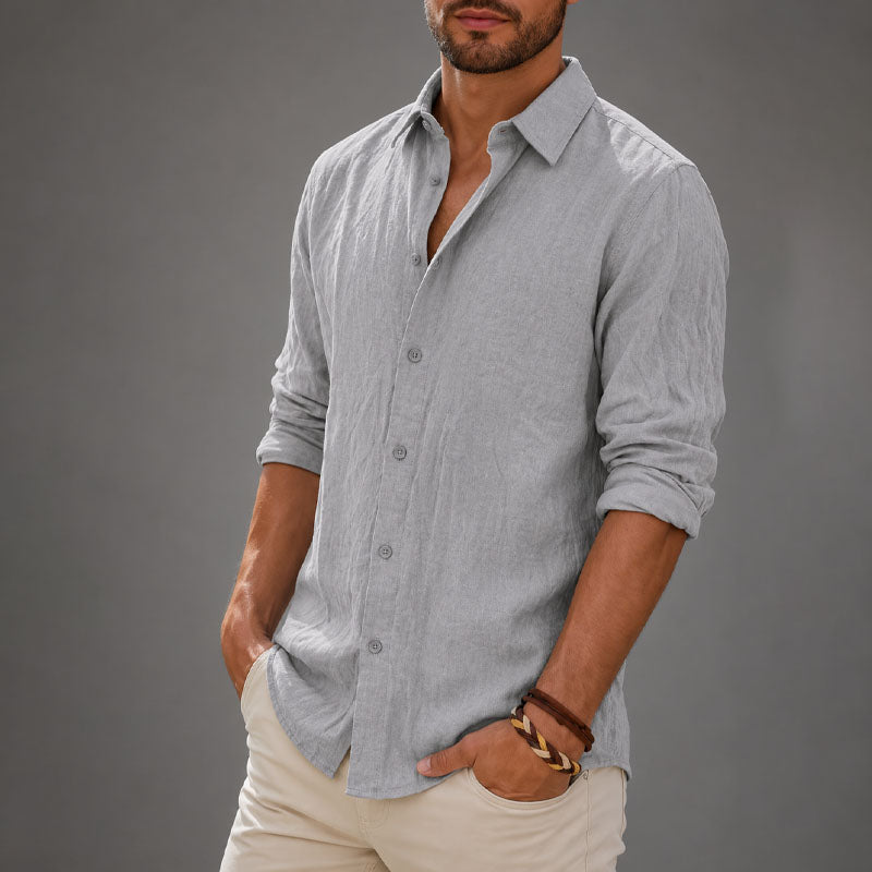 
Male model in a relaxed button front shirt with soft drape on a plain background.