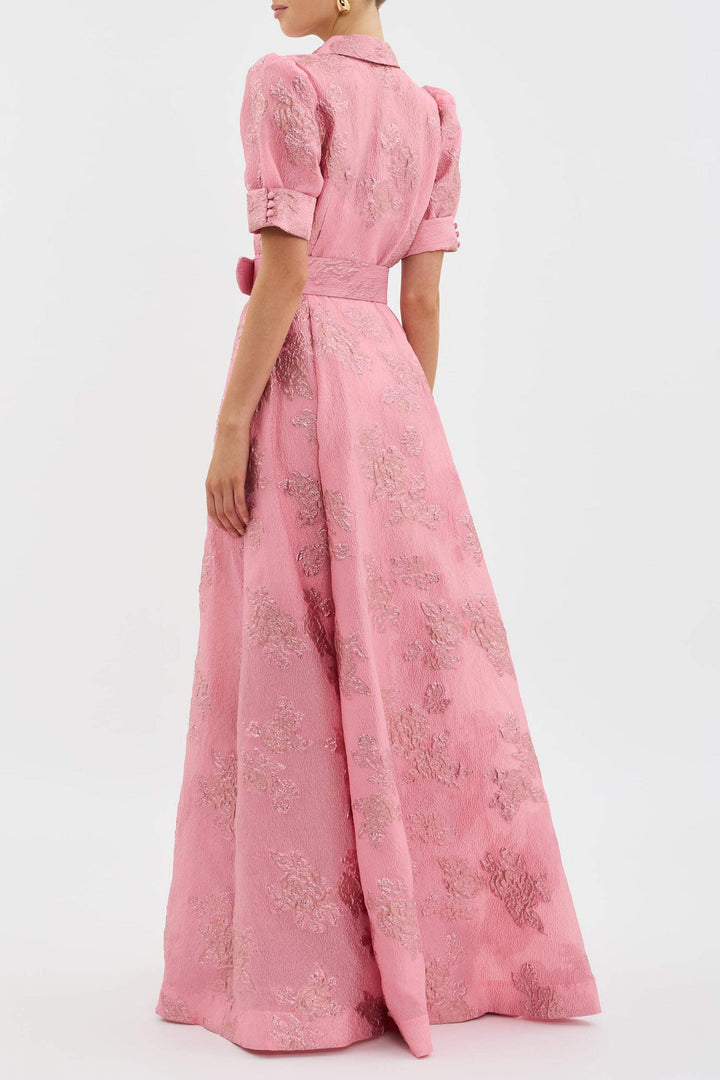 Woman in a pink vintage-inspired lapel dress against a clean background.
