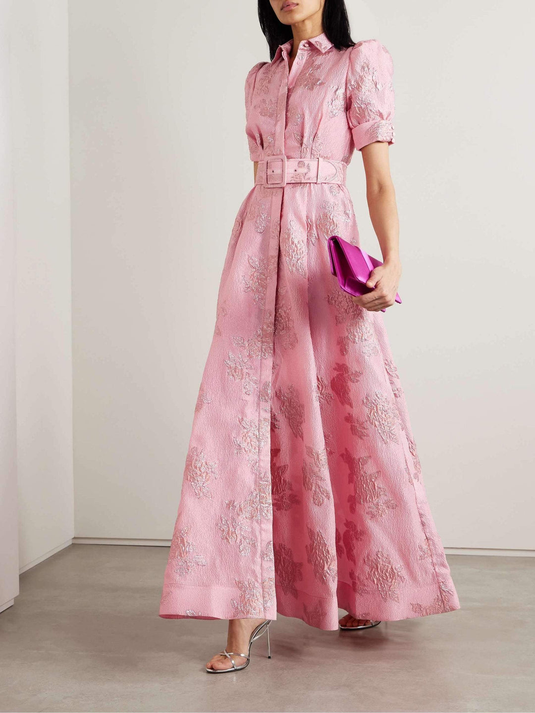 Woman posing in a pink retro-style dress on a clean studio background.