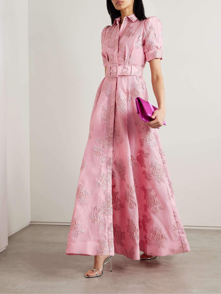 Woman posing in a pink retro-style dress on a clean studio background.