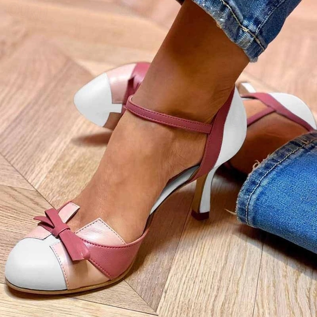 Close-up of foot in refined open-toe heel on a clean background.