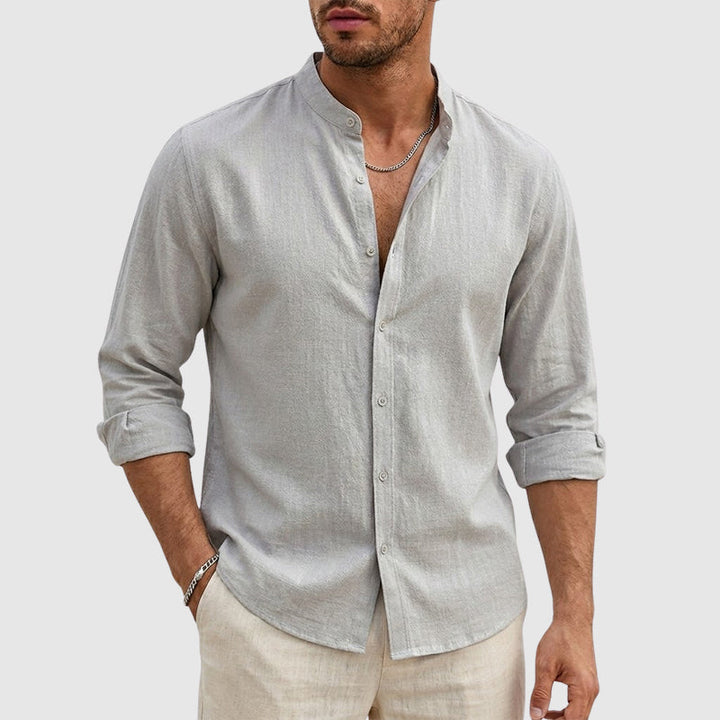 Woman standing in a lightweight woven shirt with a stand collar against a plain background.