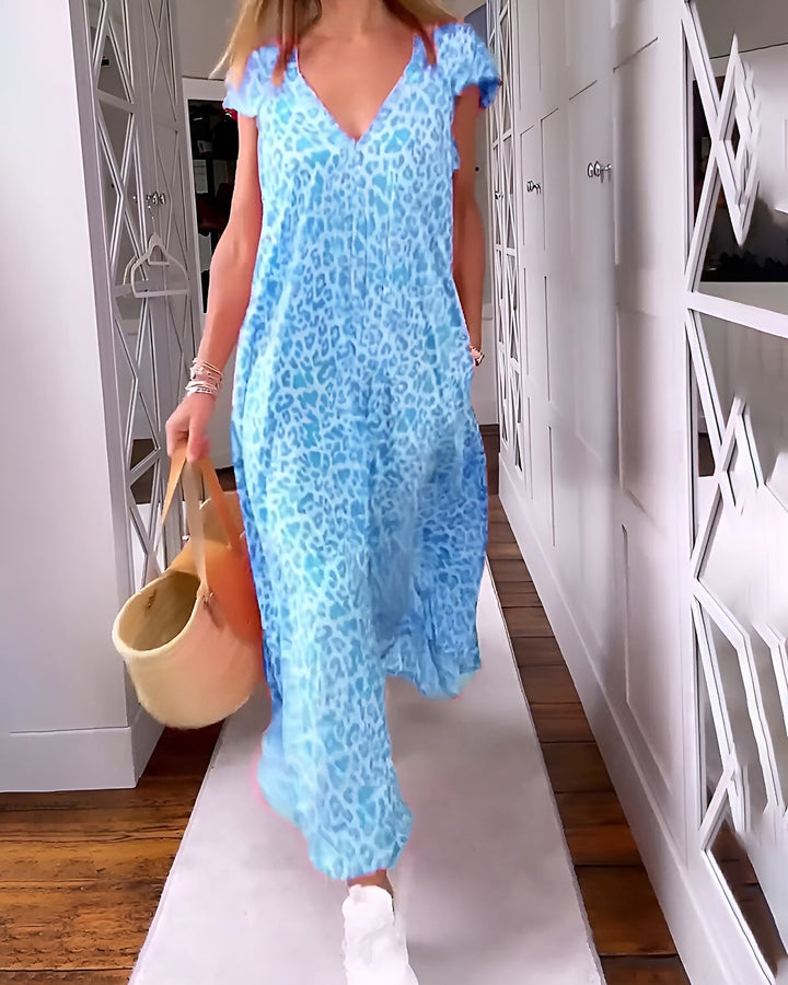 Female model showcasing a long animal print dress with a relaxed fit on a plain background.