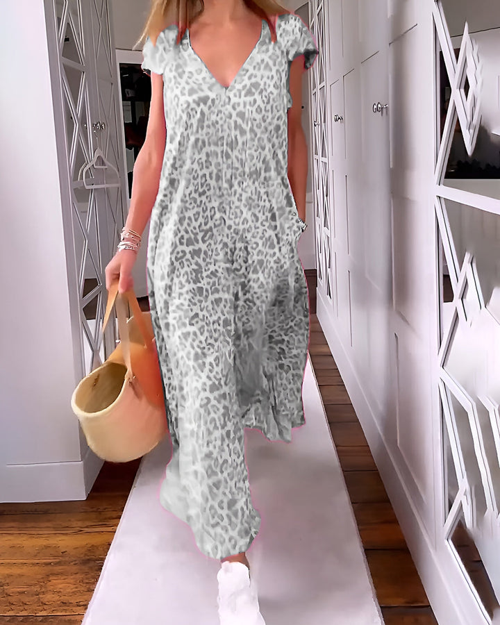 Female model in a chic leopard print maxi dress standing against a plain background.