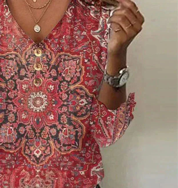 Close-up front detail of ruby blouse on plain background.