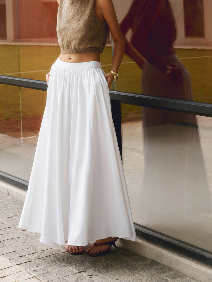 Long pleated skirt displayed on a plain background with a clean solid color finish.