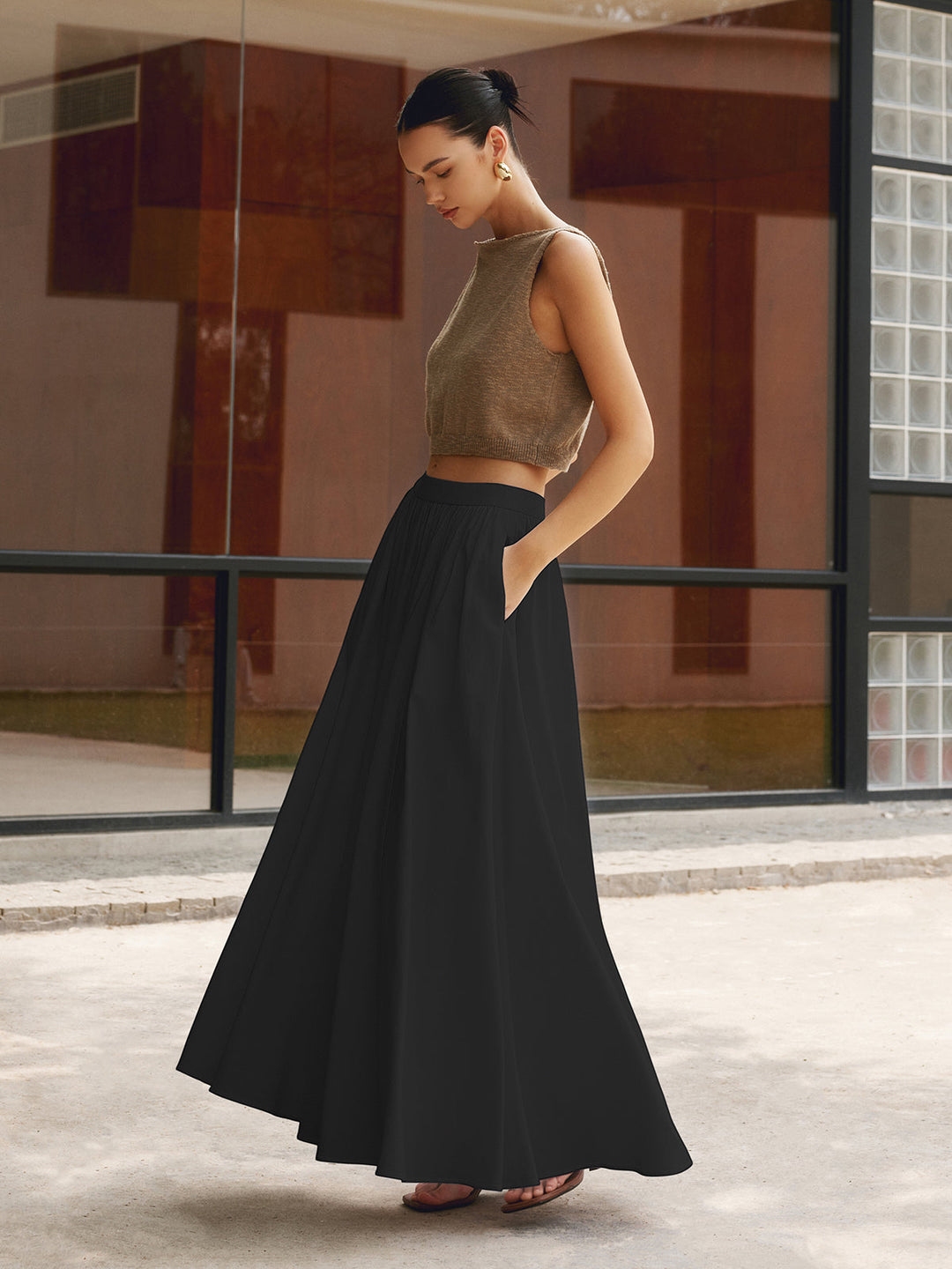 Plain background view of a high waist pleated skirt with a relaxed maxi length.