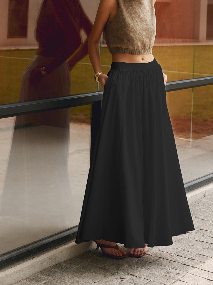 Soft pleated maxi skirt in a solid shade displayed against a simple plain background.