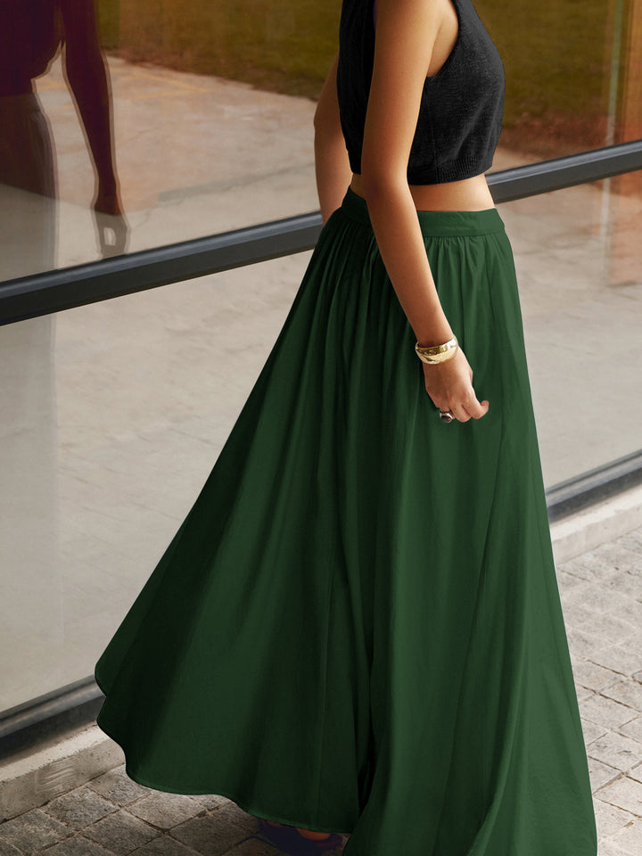 Long flowing skirt with neat waist pleats and smooth drape on plain background.