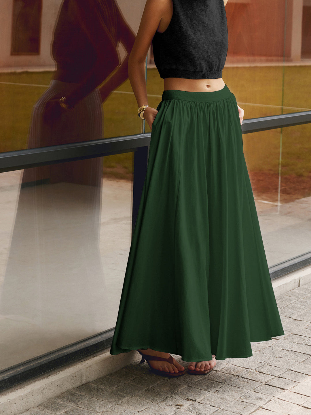 Clean solid maxi skirt with pleated detail shown on a plain studio background.