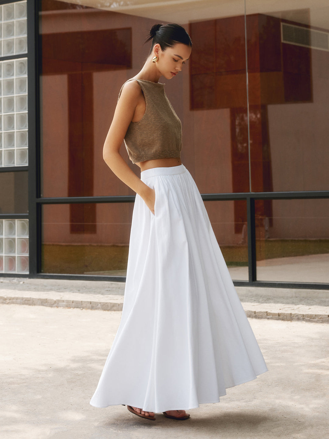 Plain background image of a flowing pleated maxi skirt with a high waist and soft drape.