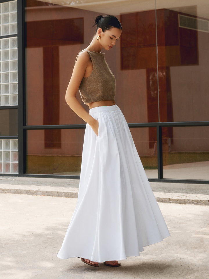 Plain background image of a flowing pleated maxi skirt with a high waist and soft drape.