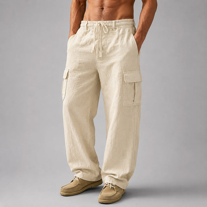  Male model in relaxed cropped pants with side pockets on a plain background.