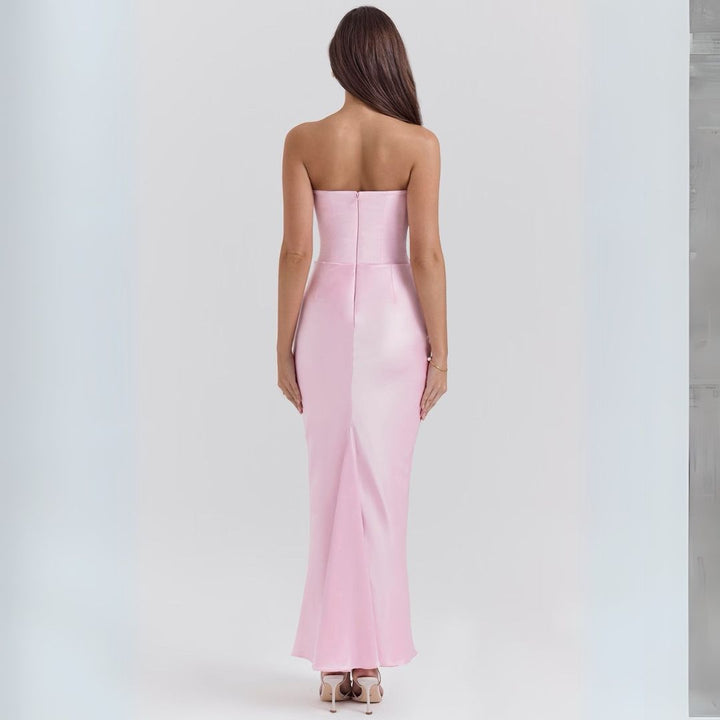 Female wearing a formal satin strapless corset dress with floor length design on a plain background, back view