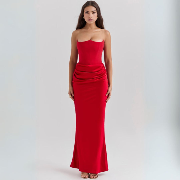Female wearing a floor length satin corset dress with strapless neckline and refined draping.