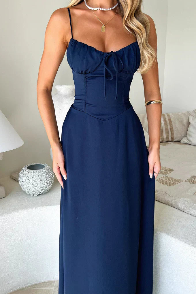 Woman in a lightweight maxi dress walking through a clean background.