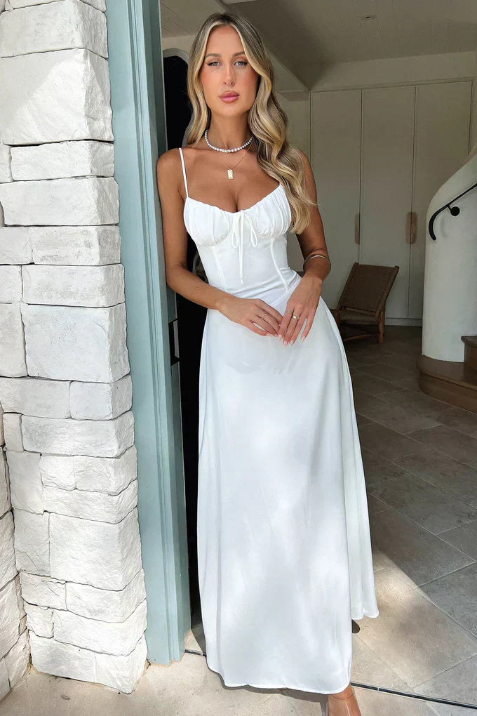 Woman posing in a wrap-style maxi dress with soft indoor background