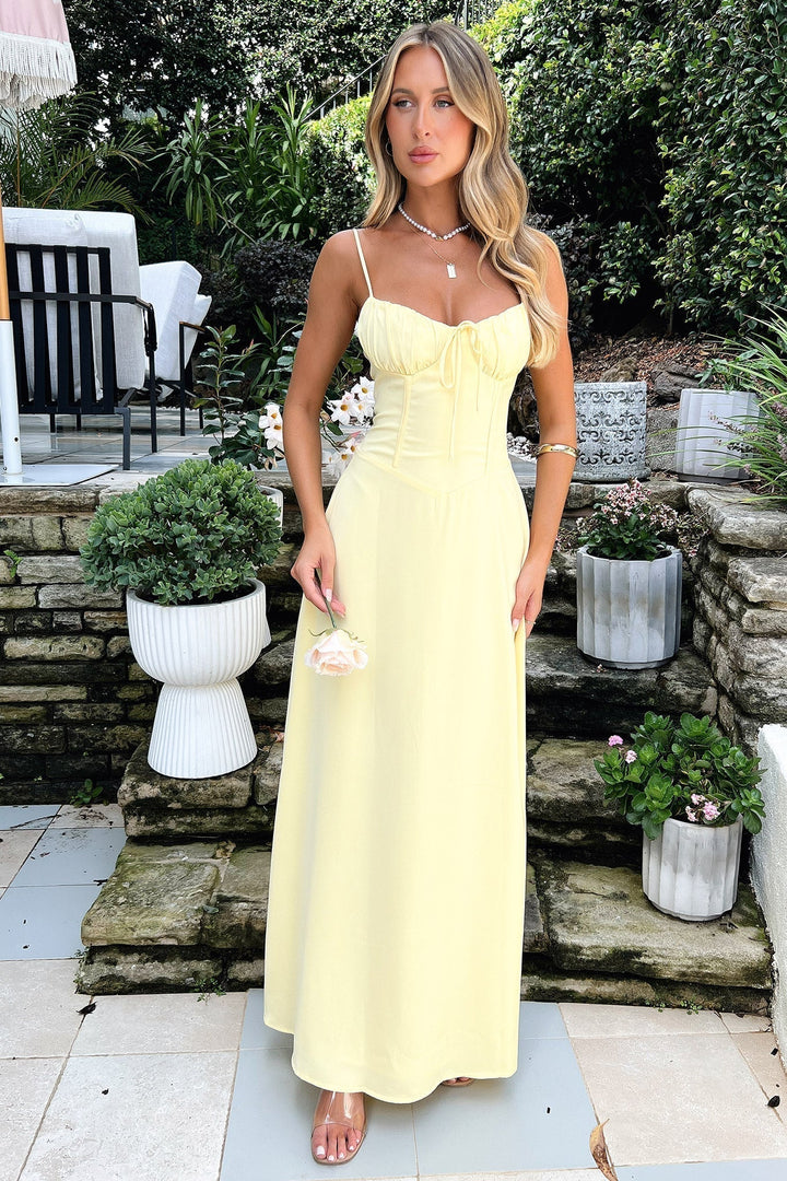 Female model wearing a flowing maxi wrap dress in a clean nature background.