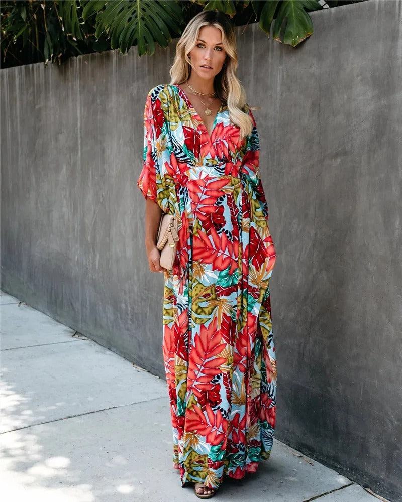 Female wearing a flowing wrap maxi dress on a plain background.