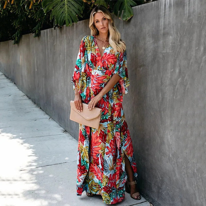 Woman wearing a relaxed fit maxi dress with kimono sleeves on a plain background.