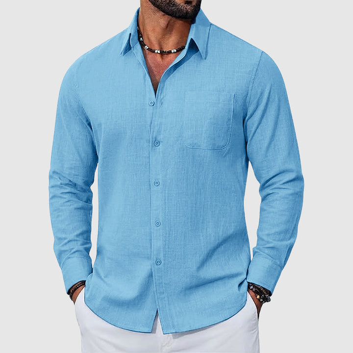 Female wearing a button-up shirt with a chest pocket against a plain background.