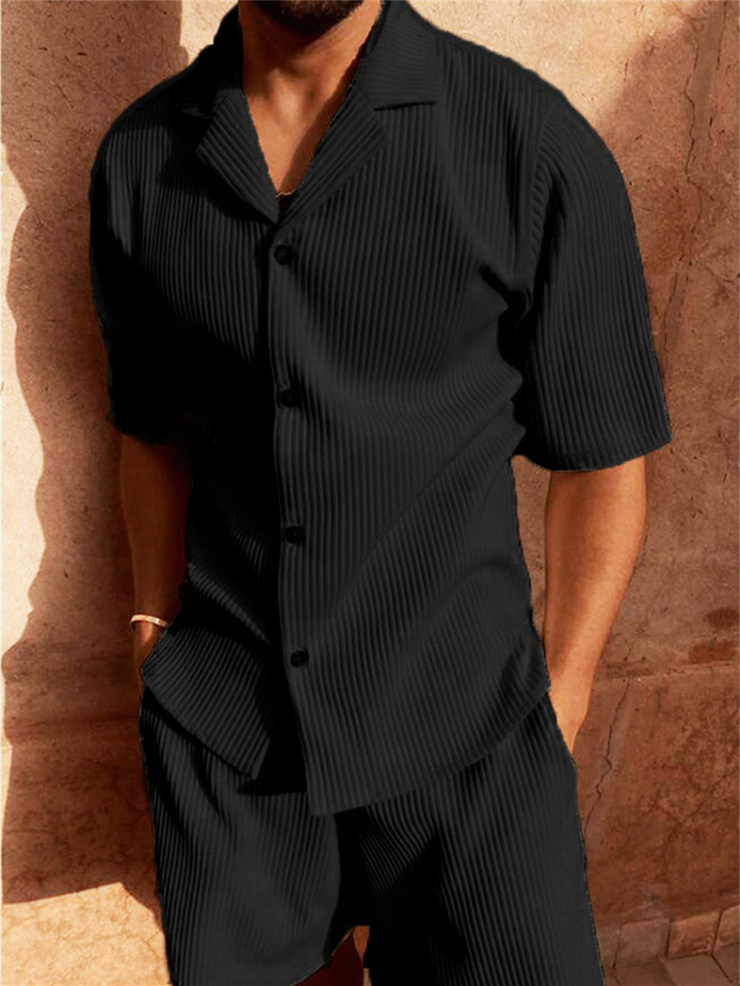  Male model showcasing a coordinated ribbed shirt and shorts outfit against a plain background.