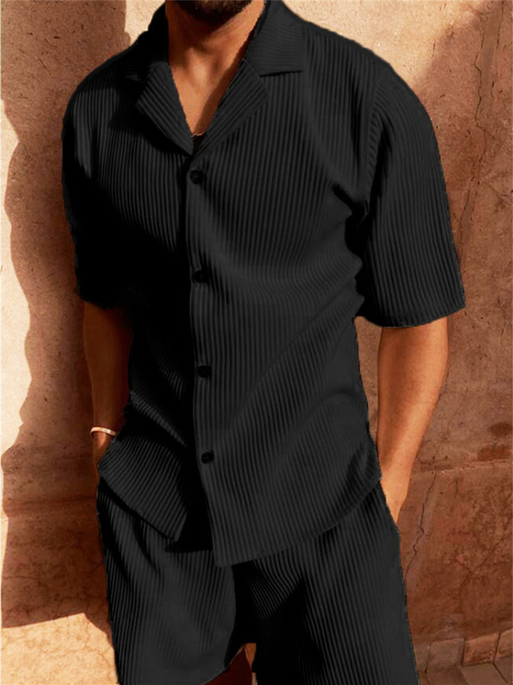  Male model showcasing a coordinated ribbed shirt and shorts outfit against a plain background.