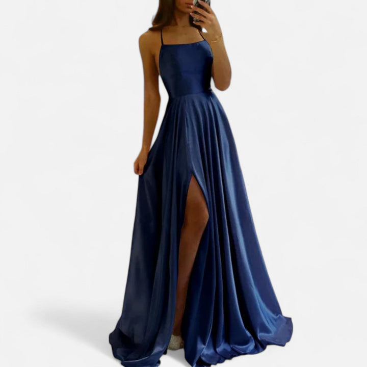 Female model side angle in long dress on plain white.