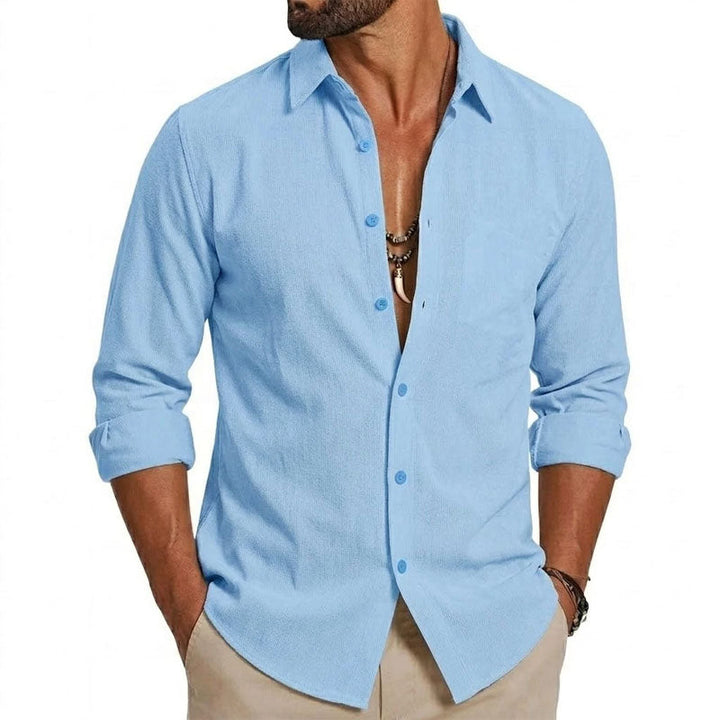  Male model showcasing a navy collared shirt with contrast accents on a plain background.