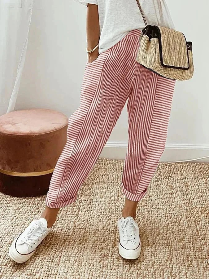 Woman in vertical striped pants standing on a clean background.