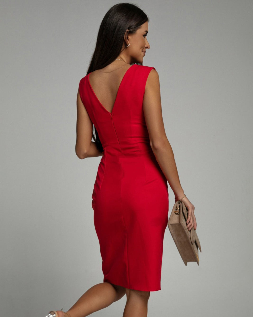 Woman posing in a fitted sleeveless dress featuring a deep V-neck and sleek silhouette.