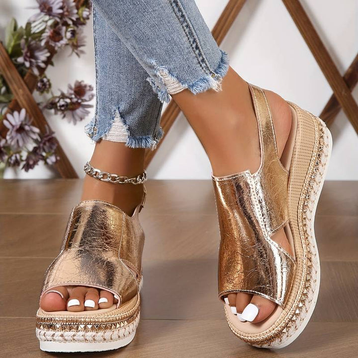 Woman’s feet displayed in stylish supportive sandals against a plain background.