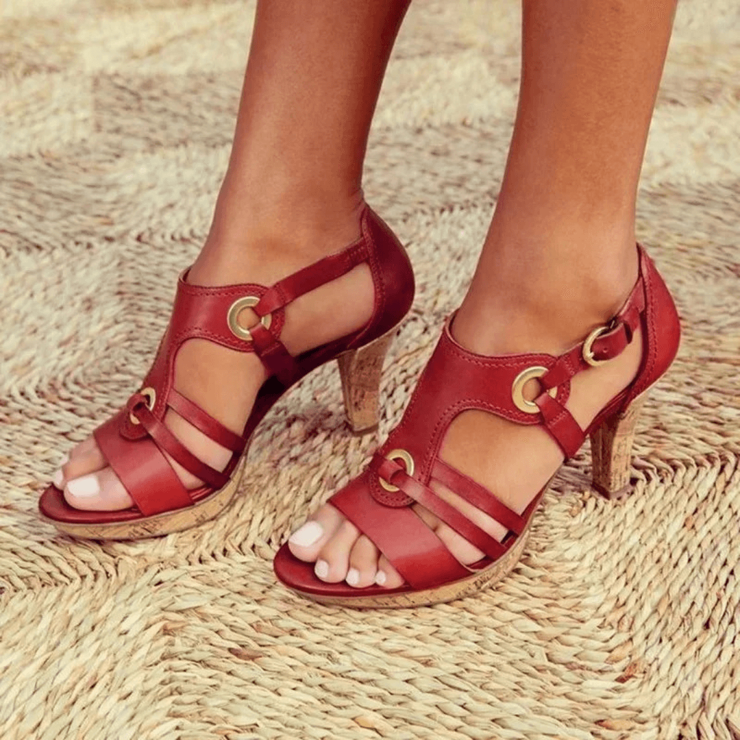 Female model wearing stylish heeled sandals against a plain background.
