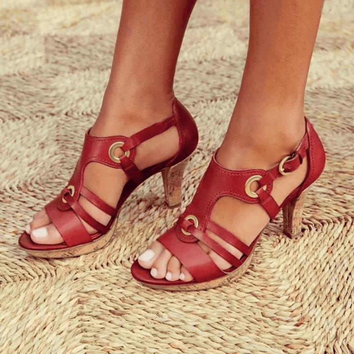 Female model wearing stylish heeled sandals against a plain background.